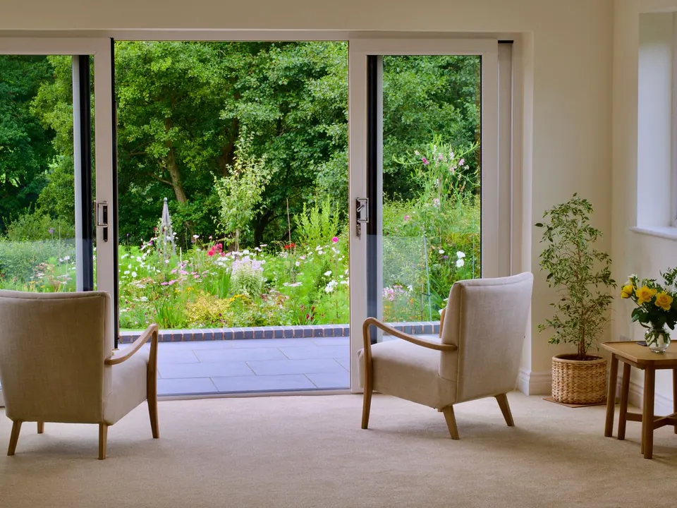Wide sliding glass patio door opening onto a flower garden